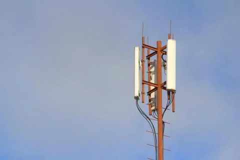 Base station mobile network antenna on a steel structure mast with a repeater. Stock Photos