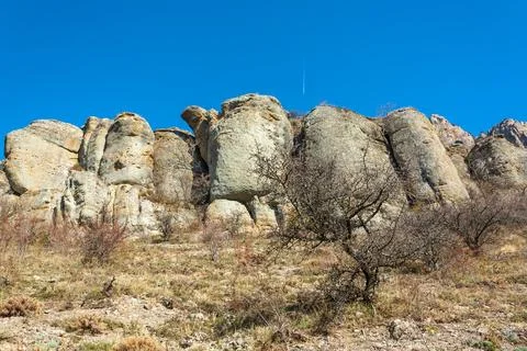 Base of towering cliffs with clear blue sky wide angle landscape Stock Photos