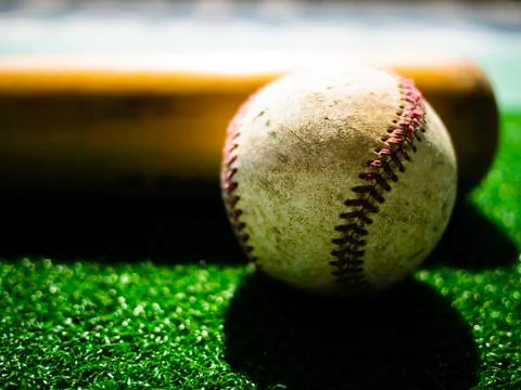 A baseball ball and Bat on Green Grass Stock Photos