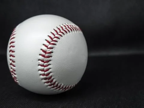 Baseball ball with red threads on a dark background Stock Photos