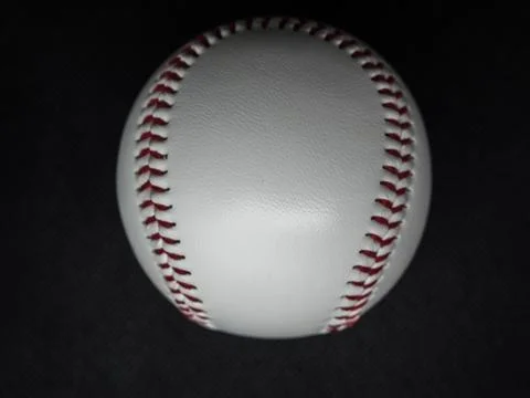 Baseball ball with red threads on a dark background Stock Photos