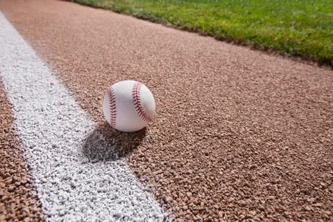 Baseball on a base path under lights at night Stock Photos