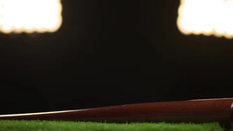A baseball bat spins under the stadium lights. Stock Footage 72358769
