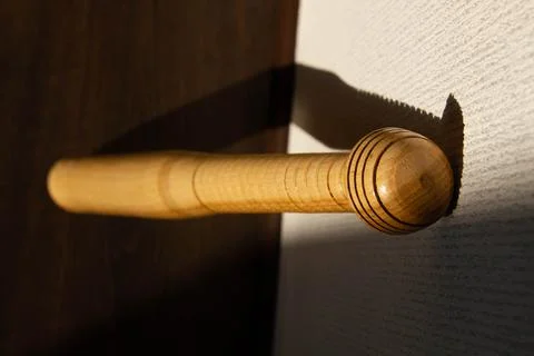 A baseball bat stands against the wall. Beautiful shadow of the sun Stock Photos