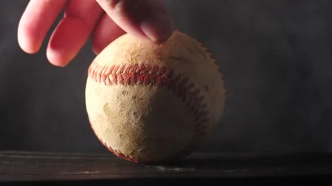 Baseball being spun in slow motion isolated on black smoke rising Stock Footage 206835808