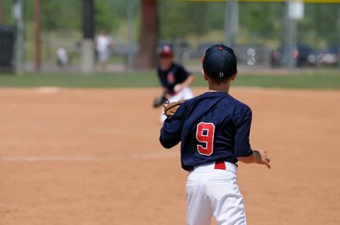 Baseball boy catching ball on first base Stock Photos