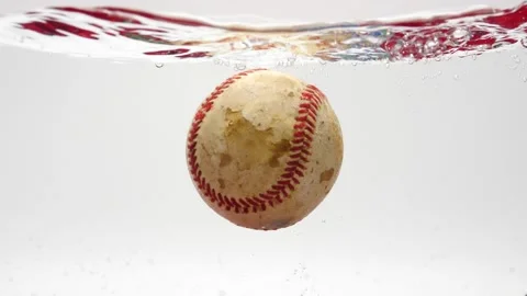 Baseball falling into water in slow motion isolated on white Video stock 219443597