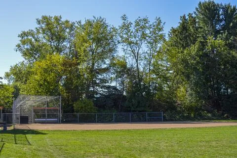 Baseball field with backstop and trees in the background Stock Photos