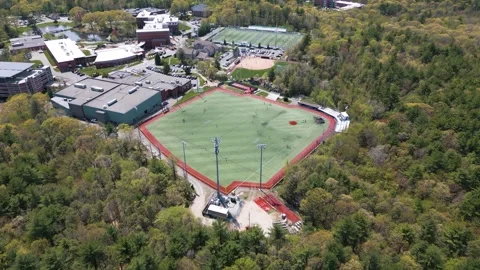 Baseball field with players on it surrounded by trees 4K aerial Stock Footage 241277989