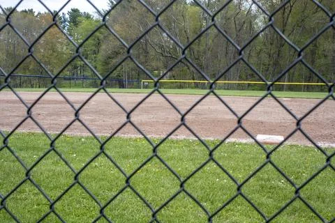 Baseball field seen through a black chain-link fence. Stock Photos