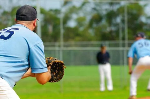 Baseball game, first baseman is getting ready to catch a ball from a pitche.. Stock Photos