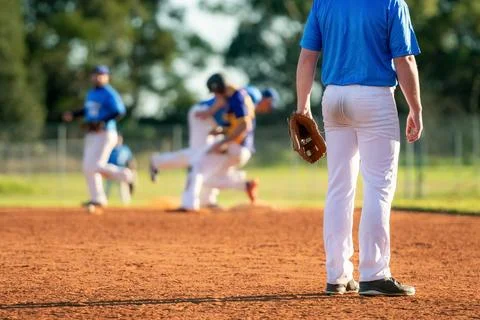 Baseball game, infielder on the third base is watching the close play on th.. Stock Photos