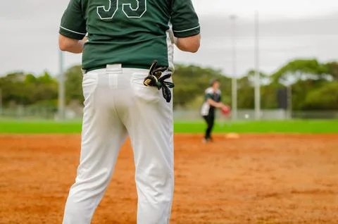 Baseball game, runner on the third base is watching the play and getting re.. Stock Photos
