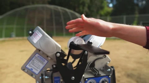 Baseball machine loading pitch for a training session outdoors Stock Footage 303883975
