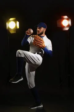 Baseball pitcher preparing to throw ball, athletic performance and sports tra Stock Photos
