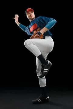 Baseball pitcher taking aim on black background Stock Photos
