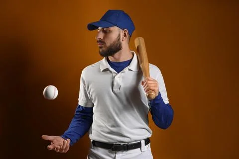 Baseball player in blue cap and white uniform holding bat with ball in mid-ai Stock Photos