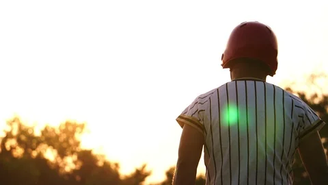 Baseball player holding a baseball bat with the light of the sunset Stock Footage 106137797
