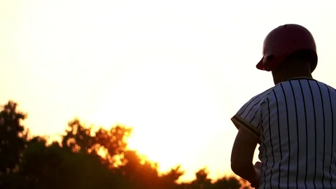 Baseball player holding a baseball with the light of sunset Stock Footage 106137550