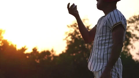Baseball player holding a baseball with the light of sunset Video stock 106137576