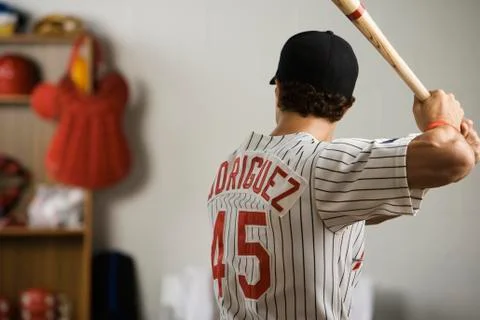 Baseball player practicing swing in locker room Foto stock