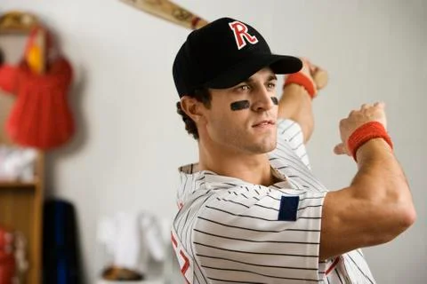 Baseball player practicing swing in locker room Foto stock