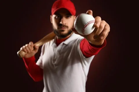 Baseball player in red cap and white polo shirt holding bat and ball, sports  Stock Photos