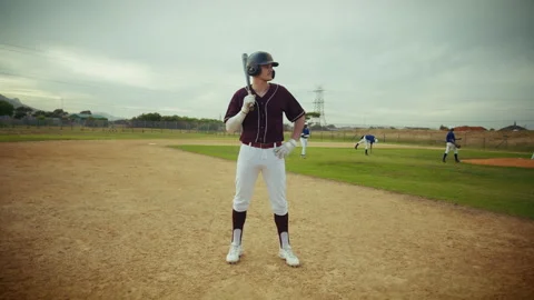 Baseball player stands ready on the field, bat in hand 動画素材 336945657