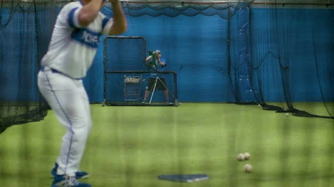 Baseball player swinging at a pitching machine. Stock Footage 134495859