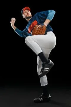 Baseball player in a wind up position on black background Stock Photos