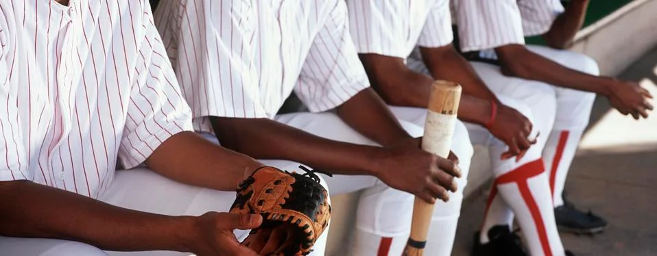 Baseball Players Sitting Together In Dugout Stock Photos