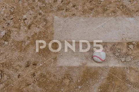 Baseball resting on pitcher plate Stock Photos