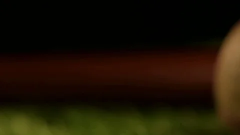 A baseball spins in front of a bat on artificial turf. Stock Footage 72536658