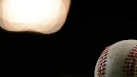 A baseball spins slowly under stadium lights in this close up. Stock Footage 72536910