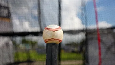 Baseball on a tee with training net behind it, slow motion movement Stock Footage 277541464