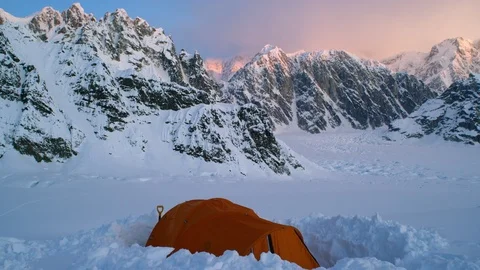 Basecamp surrounded with thick layer of snow and mountains in sunrise, Alaska Stock Footage 129127169