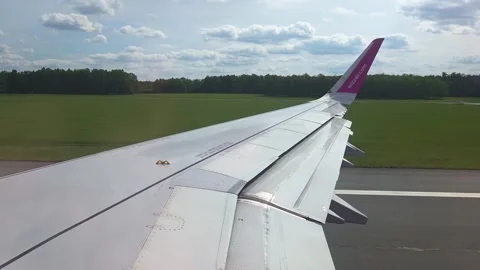 Basel, Switzerland, May 25, 2026: Airplane wing view during landing approach Stock Footage 342156383