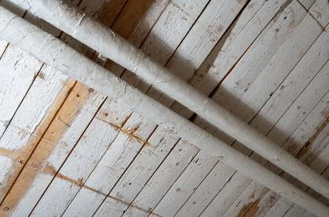 Basement ceiling with exposed pipes and wooden structure Stock Photos