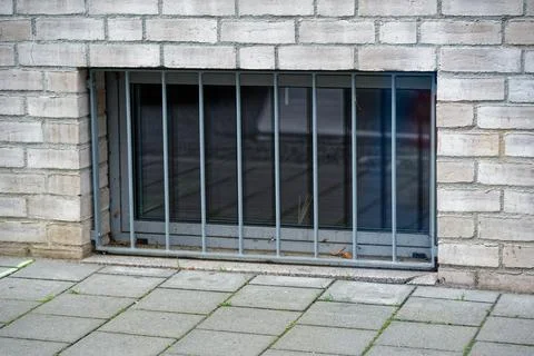 Basement level window with security bars near street Stock Photos