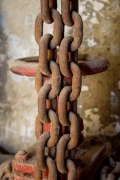 Basement, water valve, Old rusty chains hang on the background of a shabby wall Fotos de archivo