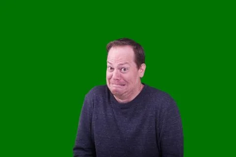 Bashful expression on male adult model on green screen backdrop Stock Photos