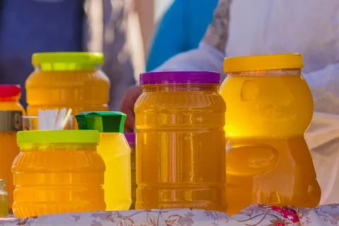 Bashkir bee honey is packaged in plastic containers of various shapes and is  Stock Photos