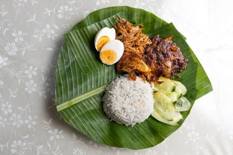 Basic authentic simple nasi lemak on banana leaf with sambal, anchovis and eg Stock Photos