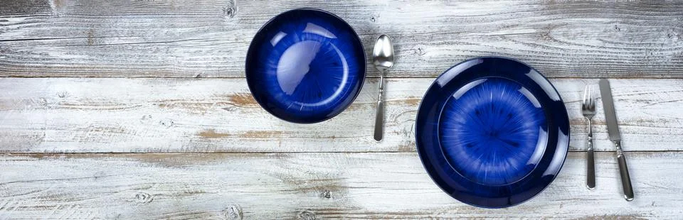 Basic dinner table setting of an empty main dark blue dish and bowl with cu.. Stock Photos