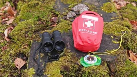 Basic Hiking Equipment Binoculars First Aid Kit and Compass Set on Forest Moss Video stock 308667446