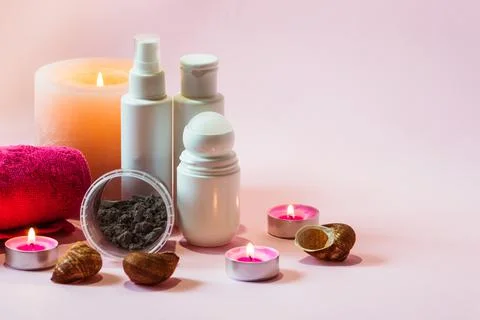 Basic hygiene products in bottles, an alginate mask and a pink towel. Stock Photos