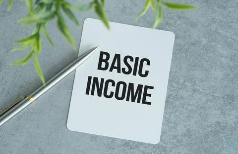 Basic income text on paper notepad, concept background Stock Photos