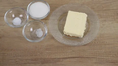 Basic ingredients for baking a cake are positioned on a wooden table Stock Footage 316630991