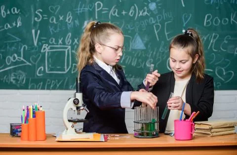 Basic knowledge of chemistry. Pupils cute girls use test tubes with liquids Foto stock
