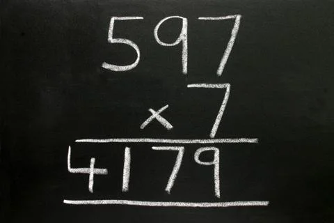 A basic multiplication sum on a blackboard. Stock Photos